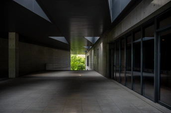 一条长长的空隧道或人行道 地板尽头有一盏绿灯