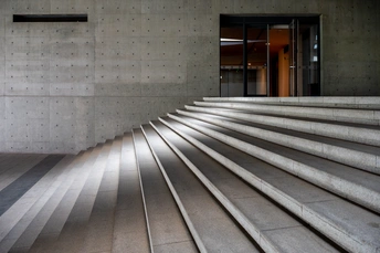 一个大型的混凝土楼梯 有混凝土墙壁 通向建筑入口的台阶。