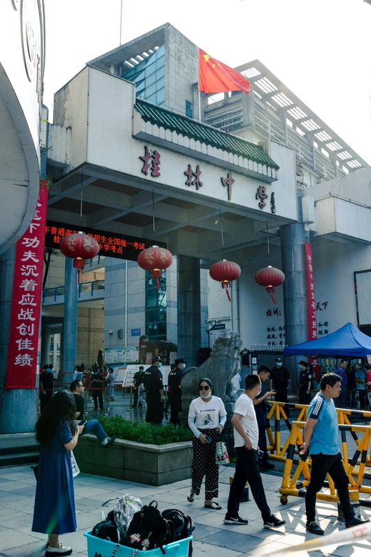 人们带着行李在街上走在一栋楼前