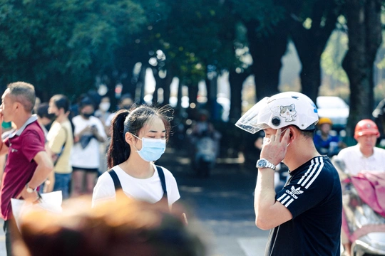 一个戴着口罩的男人遮住了脸 而一个女人走在街上