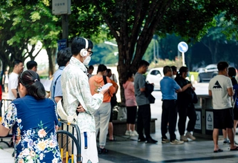 一个正在打电话的男人站在人行道上的一群人旁边