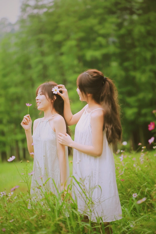 一个头发上插着花的年轻女子站在草地上