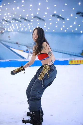 一位年轻女子在室内溜冰场雪上滑板。