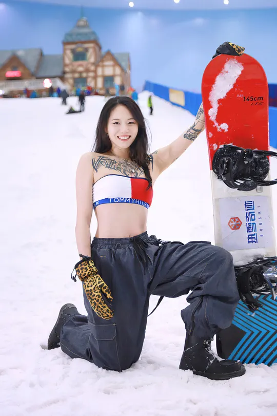 一位年轻女子在雪中持有一块滑板