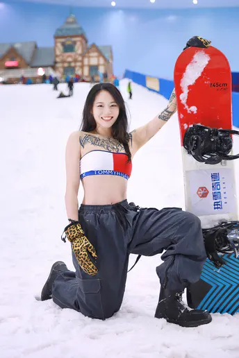 一位年轻女子在雪中持有一块滑板