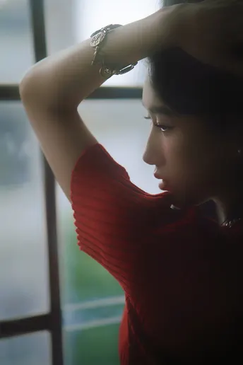 一个年轻女子站在窗前 头埋在手里