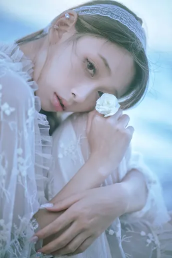 一位穿着白色连衣裙的年轻女子肖像 带着一朵花