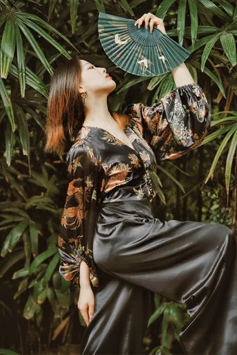 一位穿着黑色和服的女人拿着扇子