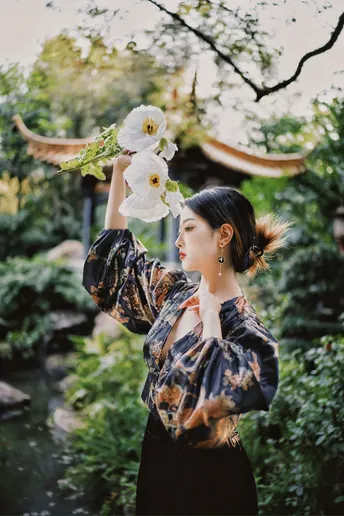 一位穿着和服的女士抱着白色花朵