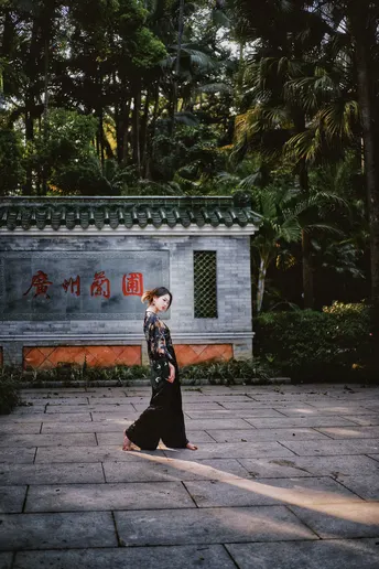 和服着の女性が苔の庭で歩いています