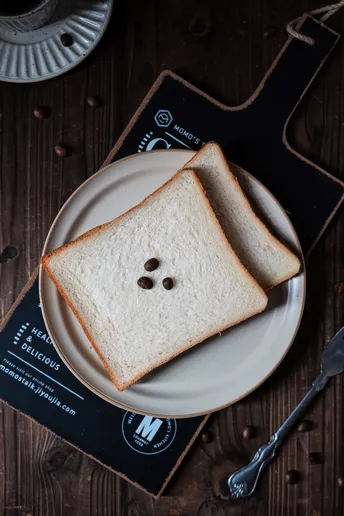 一张带有食物人脸图案的白盘子和一杯咖啡