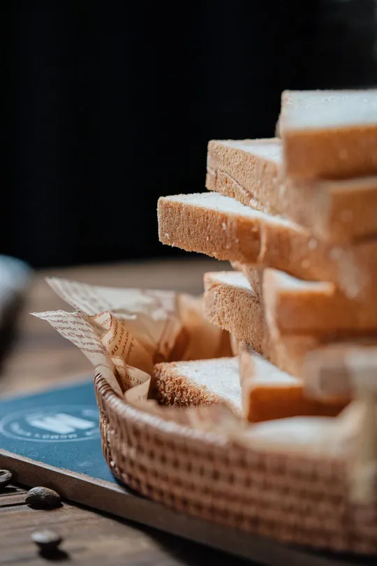 一片木桌上放着一堆面包和一些 cheese 在盘子里