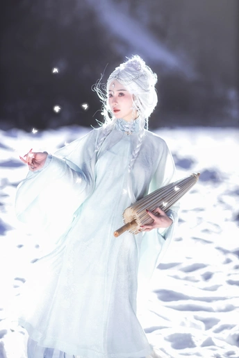 一位穿白色连衣裙的女子在雪中