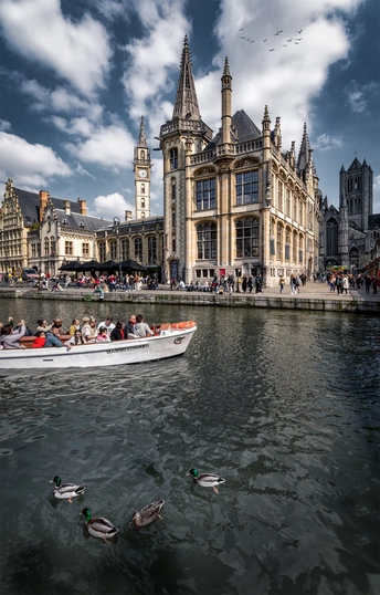 一艘小船在有鸭子和背景建筑的湖泊中