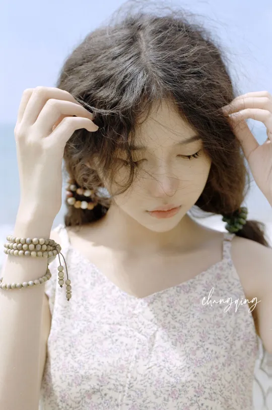 一位年轻女子穿着一件白色连衣裙 头戴珍珠项链。