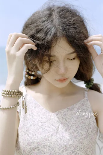 一位年轻女子穿着一件白色连衣裙 头戴珍珠项链。