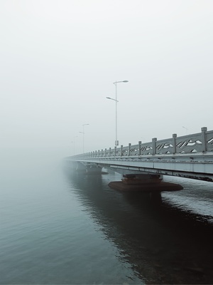 雾气笼罩的早晨 水面上的一座桥。