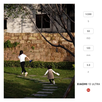 一个在公园里玩飞盘的女人 后面跟着一个小女孩和一个小男孩。