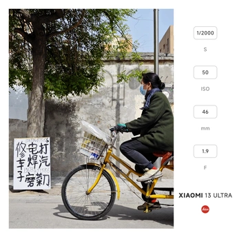 一个戴口罩的男子骑自行车沿着街道行驶