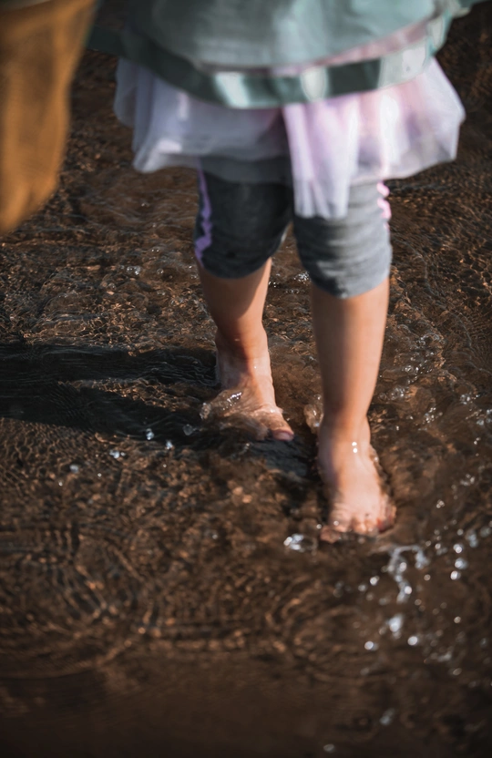 一个人站在积水坑里 双脚陷在泥里