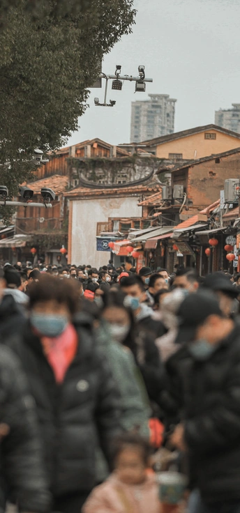 一群戴口罩的人走在拥挤的街道上