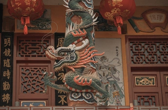 建筑前的一根杆子上有一座巨大的龙雕像。