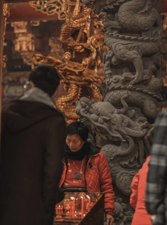 一位站在神庙前看着一个站在烛台前的男子的人