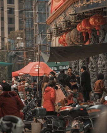 人群沿着街道走 许多摩托车和雨伞。