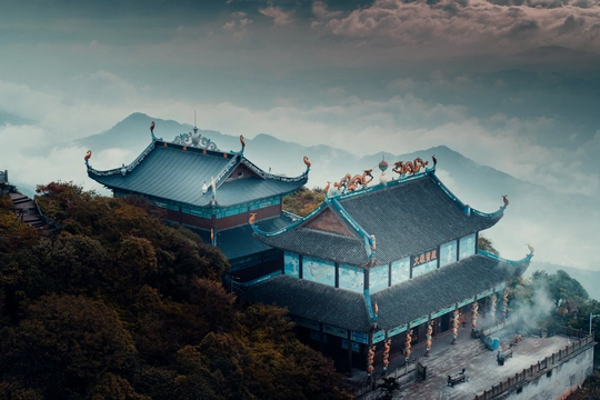 一张山上有塔、天空有云的照片