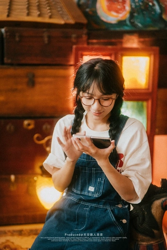 一个戴眼镜的年轻女子正在看手机