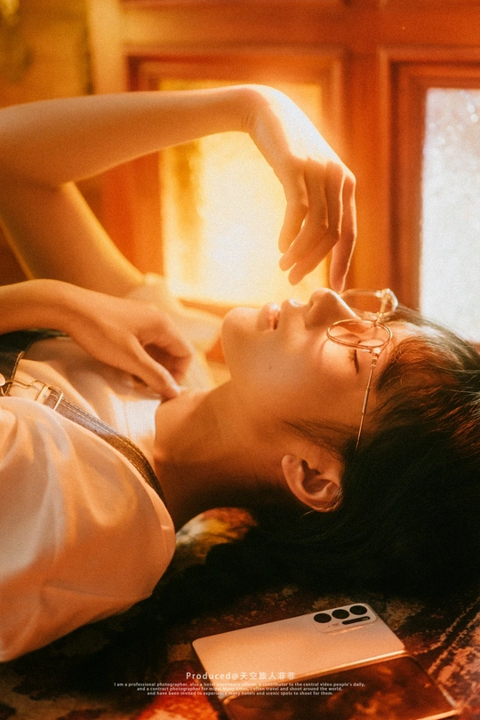 一个戴眼镜的年轻女子躺在地板上 头紧贴着床