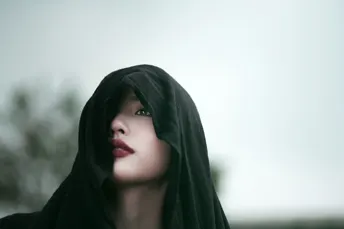 一个戴黑色兜帽的女孩脸上涂着红