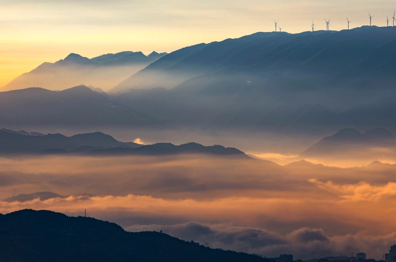 山谷上的日出或日落 远处的山丘上有风力涡轮机