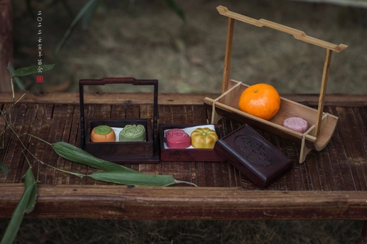 一张木桌 里面有一小盘肥皂、一盒水果和一个桔子