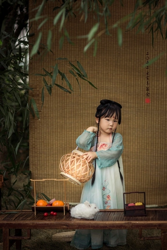 一个穿着和服拿着小篮子的年轻女孩的雕像站在一张提着灯笼的桌子前