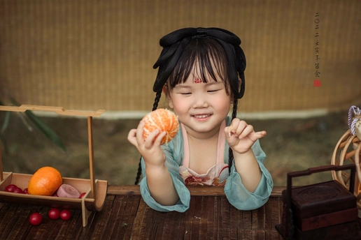 一个手里拿着橘子的小女孩