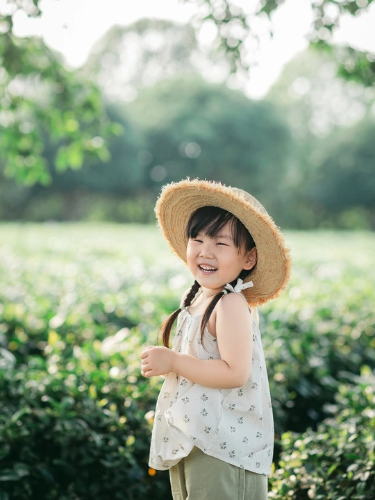 田野中站立的戴着草帽的小女孩肖像