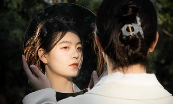 一位满头白发的女士站在镜子前