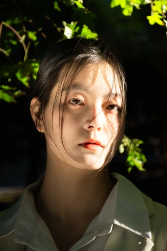 一位被阳光和树木照亮的女子的肖像