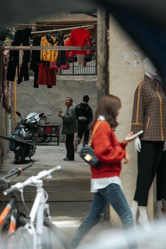 一个女人骑着自行车走在小巷里 一个男人走在街上