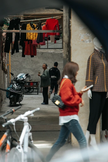 一个女人骑着自行车走在小巷里 一个男人走在街上