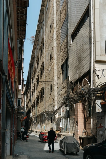 一个人走在古城的一条狭窄的街道上