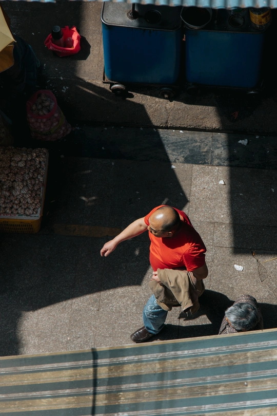 一个穿着红衬衫的男人走在人行道上