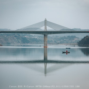 湖上的一座长桥 桥上有人乘船。