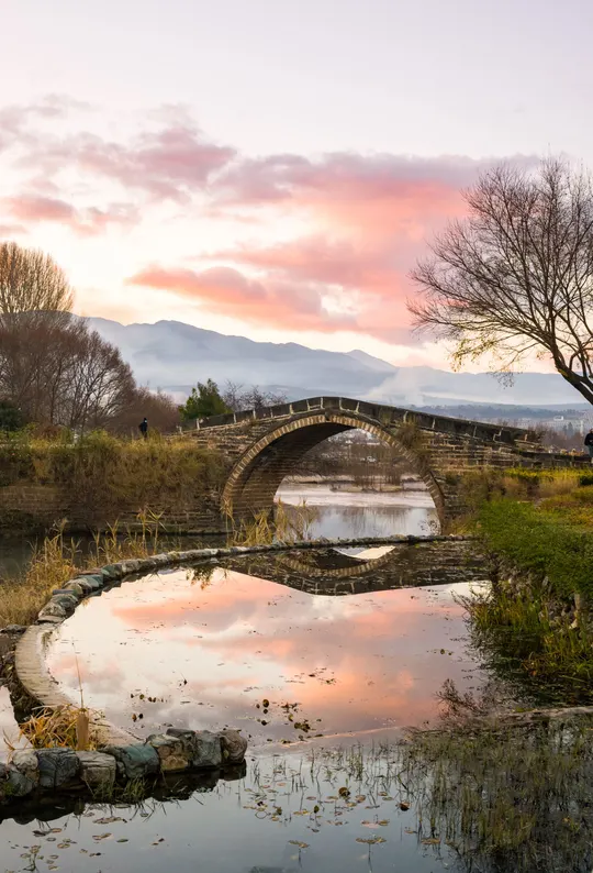 夕阳下 一座古老的石桥横跨在小溪上