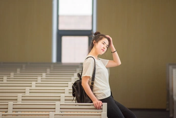 一个背着书包的年轻女子坐在教堂的长椅上