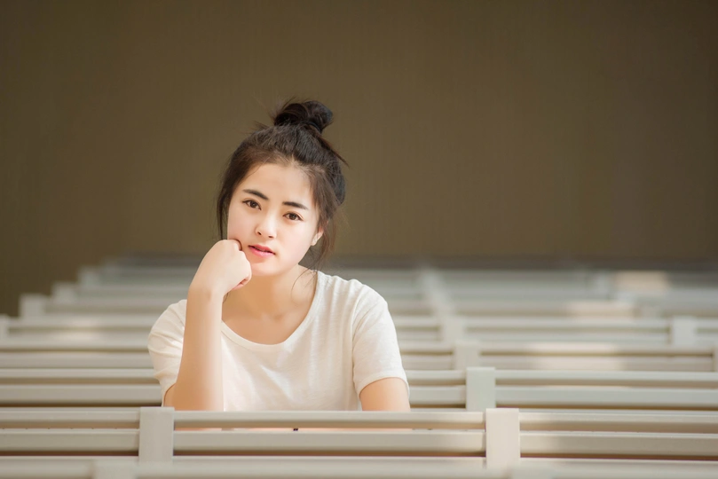 一位年轻女子坐在教堂里一张白色的桌子旁