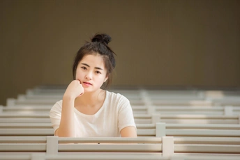 一位年轻女子坐在教堂里一张白色的桌子旁