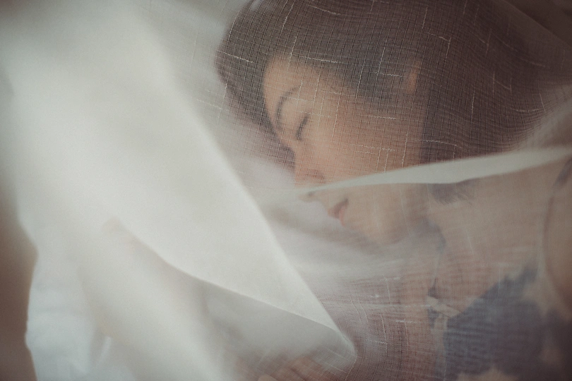 一个年轻女孩在白色面纱下隐藏