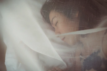 一个年轻女孩在白色面纱下隐藏